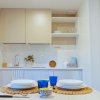 Cucina moderna con tavolo apparecchiato, bicchieri blu e piatti bianchi.