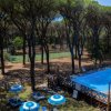 Piscina nel bosco con campi sportivi.