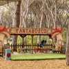 Piccolo parco giochi all'aperto con tavolini colorati e insegna 
