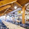 Ristorante con tavoli apparecchiati e persone sedute.
