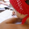 Bambino con bandana rossa che colora un libro da colorare.