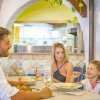 Famiglia sorridente a tavola in ristorante.