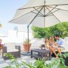 Famiglia sotto un grande ombrellone in un'area relax con sedie in vimini.