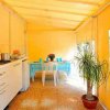 Cucina gialla con tavolo apparecchiato e pianta.