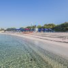 Spiaggia con ombrelloni blu e sdraio allineati sulla sabbia.