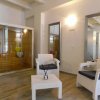 Area relax con poltrone bianche e sauna in legno.