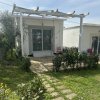 Casa bianca con pergolato e giardino.