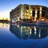Luminoso edificio illuminato riflesso in una piscina al tramonto.