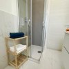 Doccia con scaffale di legno e asciugamani.