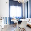 Cucina luminosa con pareti a strisce blu e bianche, tavolo bianco.