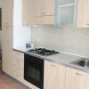 Cucina moderna con mobili in legno chiaro, piano cottura a gas e lavello.