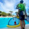 Bagnino sorveglia bambini che giocano in piscina.
