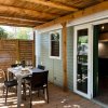 Una terrazza coperta con tavolo da pranzo e sedie, affacciata su un interno.