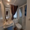 Un bagno moderno con lavabo, toilette e doccia, decorato con una tenda marrone.