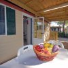 Veranda con tavolo e cesto di frutta.