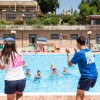 Animatori coordinano attività in piscina.
