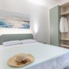 Letto matrimoniale con cappello e camicia appesi vicino.