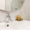 Dettaglio lavabo con specchio e prodotti.
