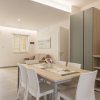 Sala da pranzo moderna con tavolo, sedie e credenza.