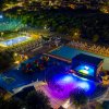 Parco giochi e piscina illuminata di notte.
