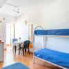 Zona letto con letti a castello blu e tavolo.