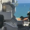 Edifici bianchi con vista sul mare e barca a vela.
