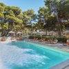 Piscina all'aperto circondata da lettini e ombrelloni.