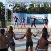 Persone partecipano a una sessione di danza davanti a un palco all'aperto.