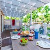 Tavolo all'aperto con colazione preparata, circondato da bungalow e alberi verdi.