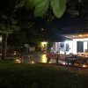 Spazio esterno notturno illuminato, con sedie e ombrellone.