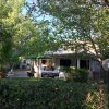 Una casa immersa nel verde con tavoli all'esterno e piante rigogliose.