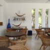Sala con tavoli, sedie intrecciate e libreria.