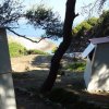 Due cabine tra gli alberi con vista sul mare.