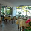 Ristorante luminoso con tavoli apparecchiati e vetrate ampie.