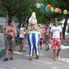 Persone in un campeggio, una indossa un colorato vestito da clown, palloncini appesi tra gli alberi.