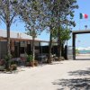 Struttura turistica con bandiere italiane, portoghesi ed europee, vista mare.