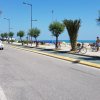 Strada costiera con una pista ciclabile, auto, biciclette e vista sul mare.