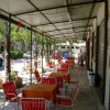 Tavoli e sedie rosse all'esterno di un ristorante coperto.