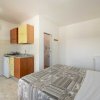 Stanza con letto matrimoniale, angolo cottura e bagno sullo sfondo.