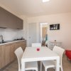 Cucina moderna con tavolo, sedie e divano rosso.