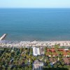 Veduta aerea di una spiaggia con ombrelloni e strutture vicine.