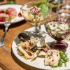 Un piatto di antipasti assortiti con frutti di mare, insalate e salse.