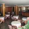 Sala ristorante con tavoli rotondi coperti da tovaglie.