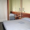 Letto matrimoniale davanti a un armadio a specchio.