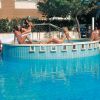 Donne sedute su una piattaforma sopra una piscina.