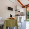 Cucina con tavolo apparecchiato e vista sul giardino.