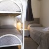 Camera con letto a castello e letto singolo, copertura grigia.
