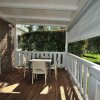 Veranda con tavolo e sedie, vista su giardino.