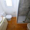 Un bagno con box doccia, lavabo, WC e bidet. Pavimento effetto legno.