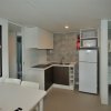 Una cucina moderna con un tavolo bianco, elettrodomestici e lavandino.